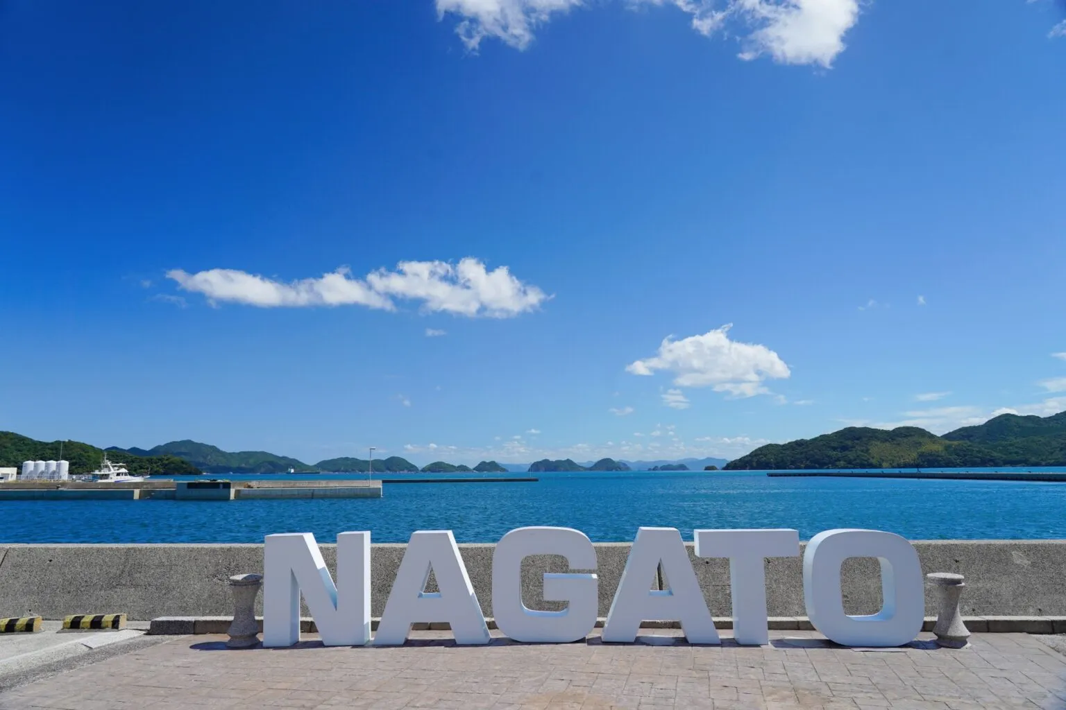 仙崎の港にある「NAGATO」の文字のモニュメントと青い海