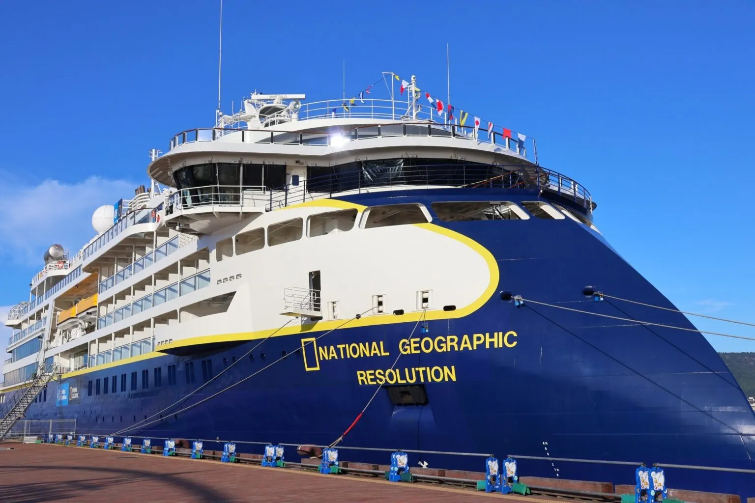 船首に「NATIONAL GEOGRAPHIC RESOLUTION」の船名がある紺色の探検船